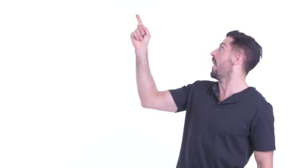 Šťastný mladý vousatý muž ukazující nahoru a překvapený — Stock video