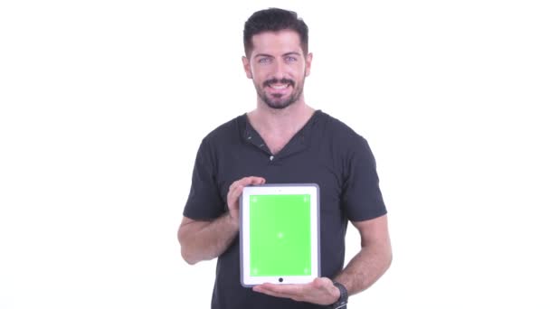 Szczęśliwy młody przystojny Brodaty człowiek rozmowa podczas pokazywanie cyfrowy tablet — Wideo stockowe