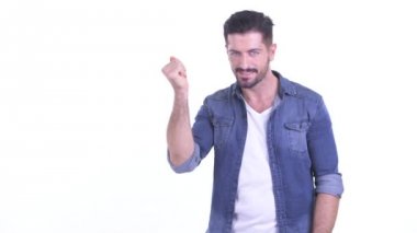 Mutlu genç sakallı hippi parmağını şıklatıyor ve bir şey gösteriyor.