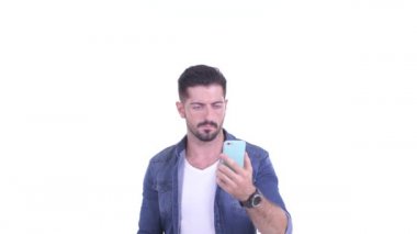 Mutlu genç sakallı hippi telefonu kullanıyor ve şaşırmış görünüyor.