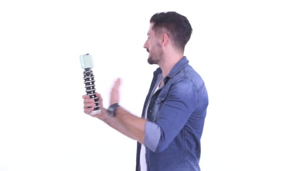 Happy young bearded hipster man vlogging and showing phone — Stock Video