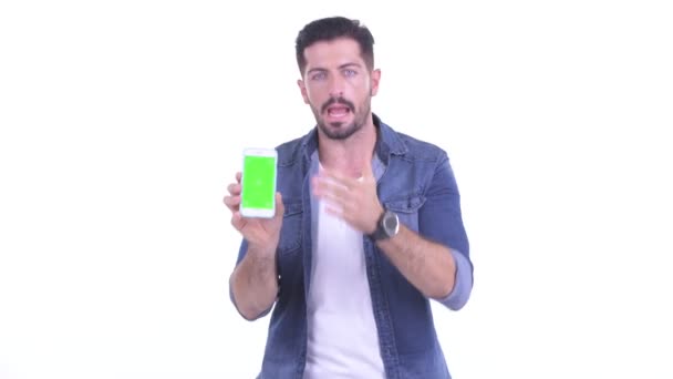 Happy Young bebaarde hipster man toont telefoon en geven duimen omhoog — Stockvideo