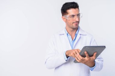 Dijital tablet kullanırken koruyucu gözlüklü genç yakışıklı doktor düşünme