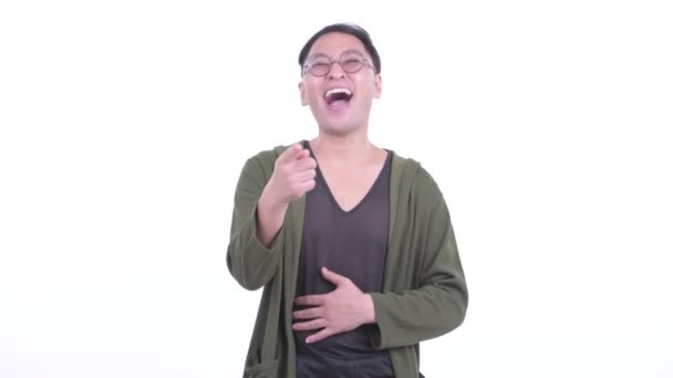 Homem japonês feliz com óculos rindo e apontando para a câmera — Vídeo de Stock