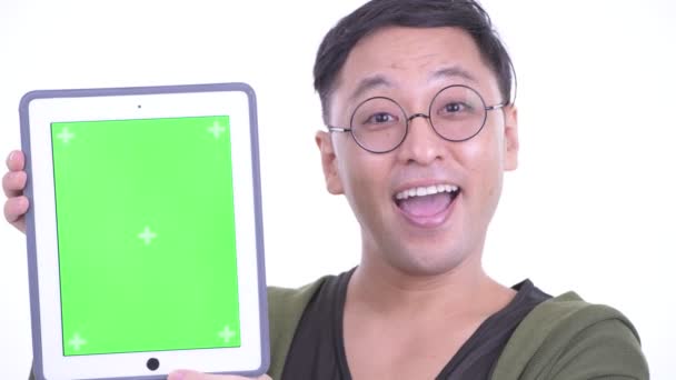 Face of happy Japanese man with eyeglasses showing digital tablet — Stock video