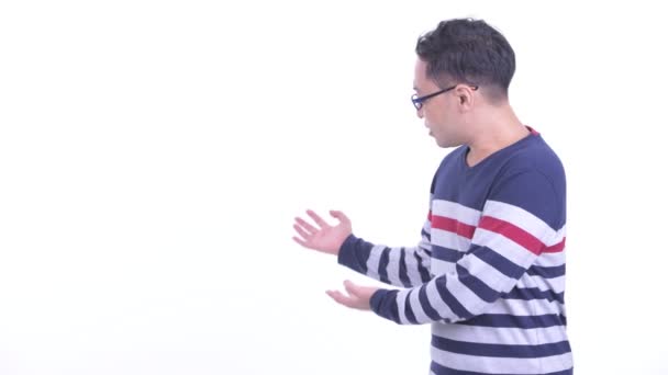 Feliz japonés hipster hombre hablando mientras mostrando a la espalda — Vídeo de stock