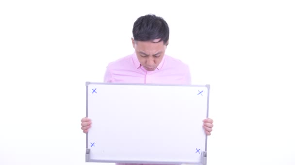 Gestresster japanischer Geschäftsmann hält Whiteboard und bekommt schlechte Nachrichten — Stockvideo