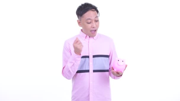 Gelukkige Japanse zakenman houdt Piggy Bank en geeft duimen omhoog — Stockvideo