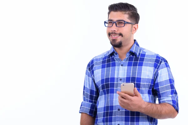 Feliz barbudo hombre hipster persa pensando mientras se utiliza el teléfono —  Fotos de Stock