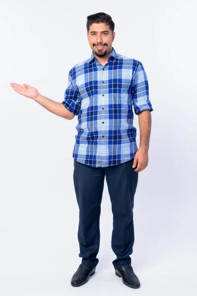 Full body shot of happy bearded Persian hipster man showing something — Stock Photo, Image