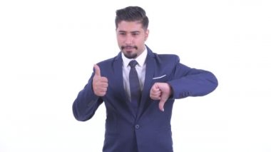 Şaşkın sakallı İranlı işadamı başparmak yukarı ve başparmak aşağı arasında seçim