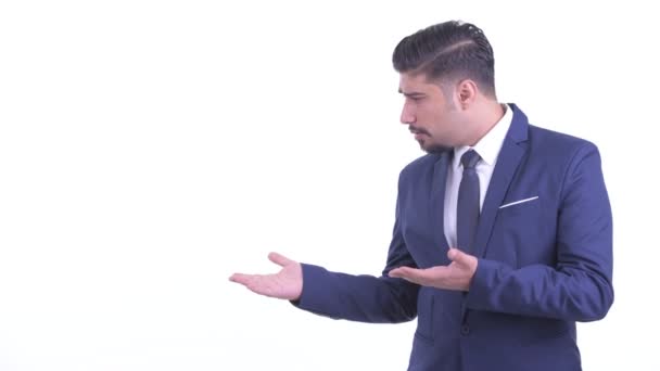 Στρεσαρισμένος με γένια περσικός επιχειρηματίας δείχνοντας κάτι και δίνοντας αντίχειρες κάτω — Αρχείο Βίντεο
