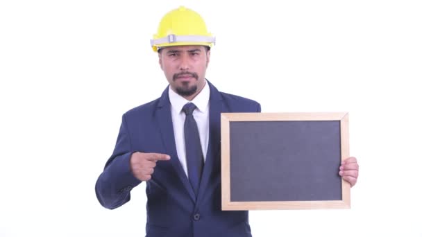 Stressed bearded Persian businessman as engineer holding blackboard and giving thumbs down — Stock Video