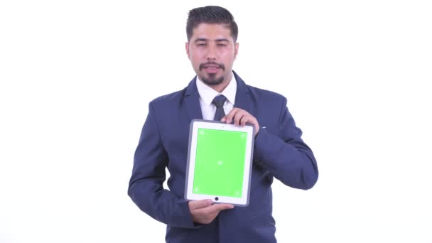 Happy bearded Persian businessman talking while showing digital tablet — Stock Video