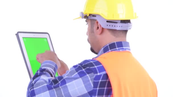 Closeup rear view of bearded Persian man construction worker using digital tablet — Stock Video