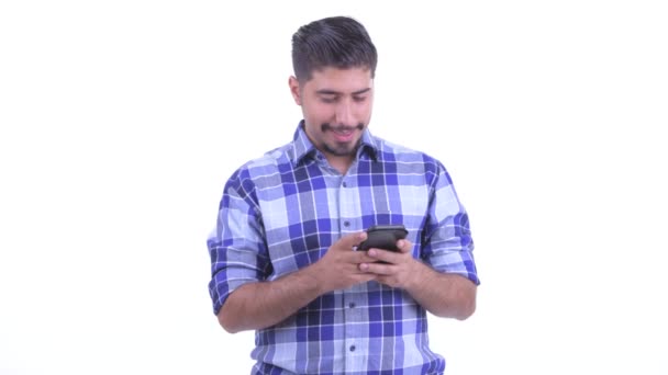 Feliz barbudo hombre hipster persa pensando mientras se utiliza el teléfono — Vídeo de stock