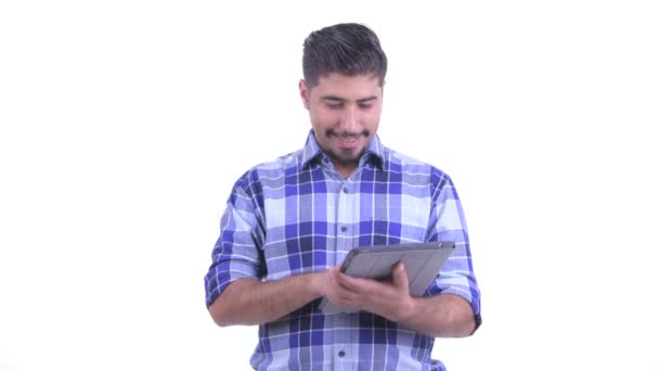 Felice barbuto hipster persiano uomo pensando durante l'utilizzo di tablet digitale — Video Stock