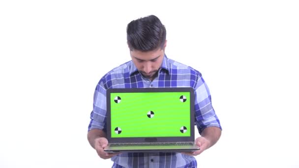 Feliz barbudo hombre hipster persa pensando mientras muestra el ordenador portátil — Vídeo de stock