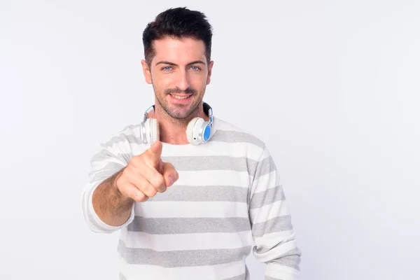 Retrato de hombre barbudo guapo feliz con auriculares apuntando a la cámara — Foto de Stock