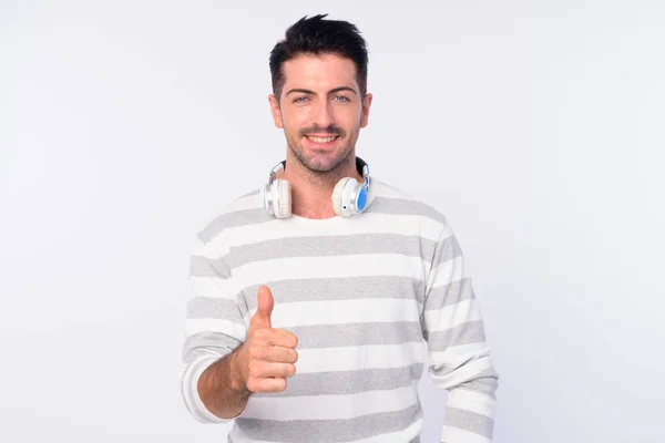 Retrato de hombre barbudo feliz con auriculares que dan pulgares hacia arriba —  Fotos de Stock