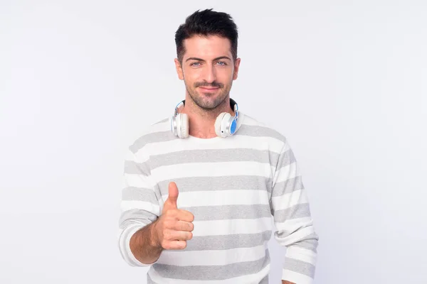 Retrato de hombre barbudo guapo con auriculares que dan pulgares hacia arriba —  Fotos de Stock