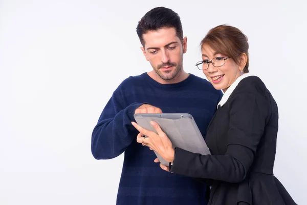 Glückliches multiethnisches Paar lächelt und nutzt gemeinsam digitales Tablet — Stockfoto