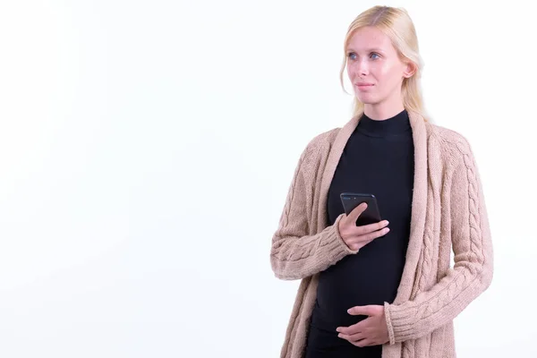 Telefon kullanırken düşünen genç sarışın hamile kadın — Stok fotoğraf