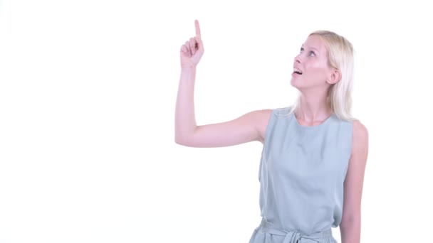 Jovem mulher loira feliz pensando e apontando para cima — Vídeo de Stock