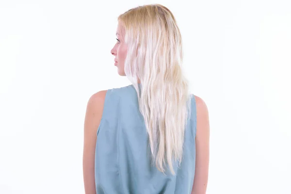 Bakifrån av ung blond kvinna som tittar över axeln — Stockfoto