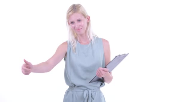 Glücklich junge schöne blonde Frau führt Regie, während sie Klemmbrett hält — Stockvideo