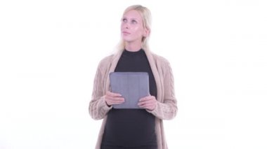 Mutlu genç sarışın hamile kadın dijital tablet kullanırken düşünme