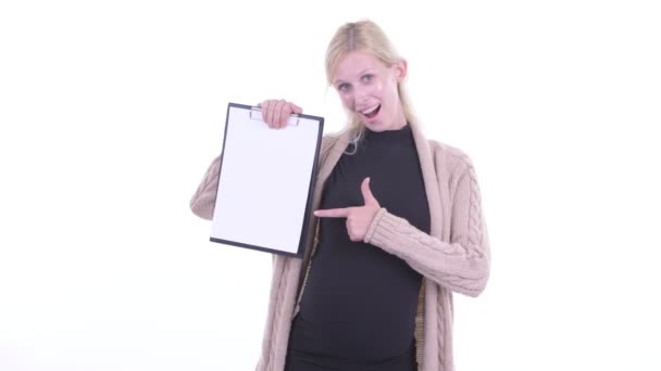 행복한 젊은 금발의 임신 한 여자는 클립 보드를 보여주는 엄지 손가락을 포기 — 비디오
