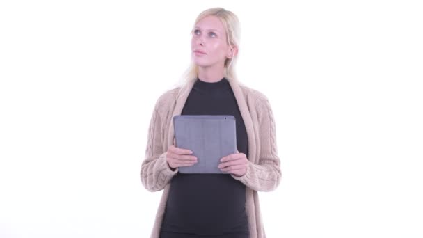 Gelukkig jonge blonde zwangere vrouw denken tijdens het gebruik van digitale Tablet — Stockvideo