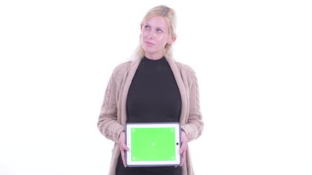 Щаслива молода блондинка вагітна жінка думає, показуючи цифровий планшет — стокове відео