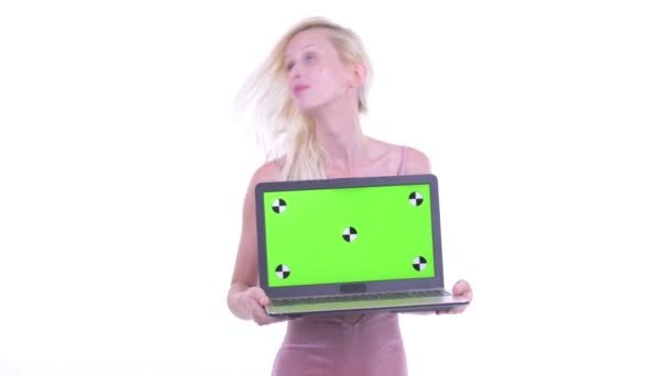 Boldog fiatal gyönyörű szőke nő gondolkodás, miközben bemutatja a laptop — Stock videók