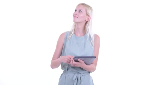 Happy young beautiful blonde woman thinking while using digital tablet — Stock Video