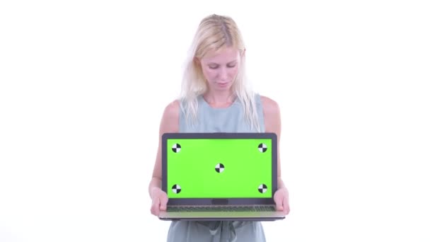 Glücklich junge schöne blonde Frau denken, während sie Laptop zeigt — Stockvideo