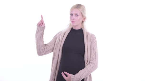 Joyeux jeune blonde femme enceinte pointant vers le haut — Video