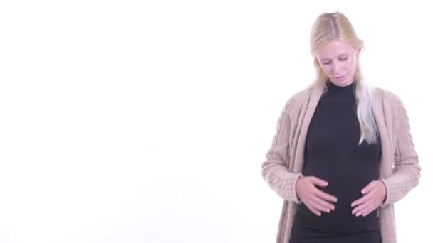 Joyeux jeune femme blonde enceinte montrant quelque chose — Video