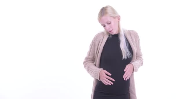 Feliz joven rubia embarazada mostrando a la espalda y mirando emocionada — Vídeo de stock