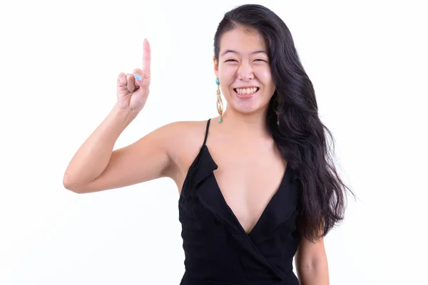 Retrato de mulher asiática bonita feliz apontando para cima pronto para festa — Fotografia de Stock