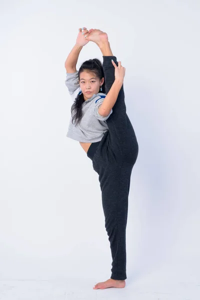 Ganzkörperaufnahme einer schönen asiatischen Frau, die sich dehnt und bereit für das Fitnessstudio ist — Stockfoto