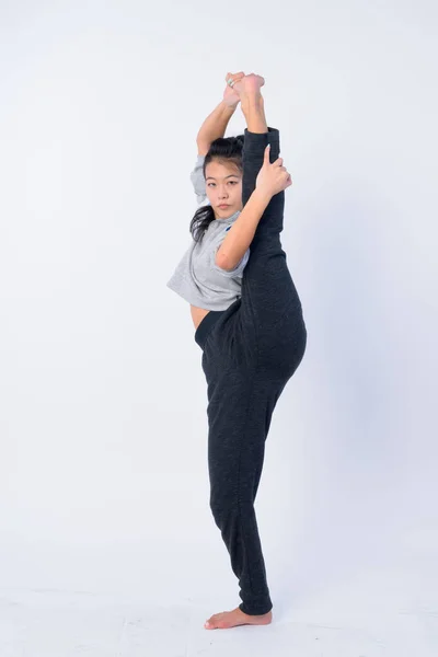 Ganzkörperaufnahme einer schönen asiatischen Frau, die sich dehnt und bereit für das Fitnessstudio ist — Stockfoto
