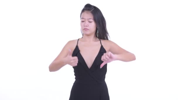 困惑的亚洲女人在大拇指向上和大拇指之间做出选择 — 图库视频影像