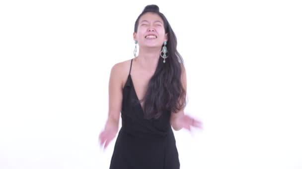 Heureuse belle femme asiatique riant et pointant vers la caméra 