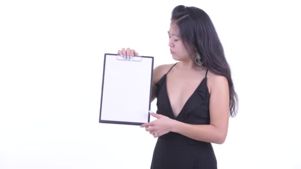 Souligné asiatique femme montrant presse-papiers et donnant pouces vers le bas — Video
