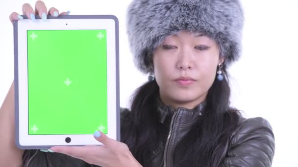 Лицо счастливой красивой азиатской женщины, показывающей цифровой планшет — стоковое видео