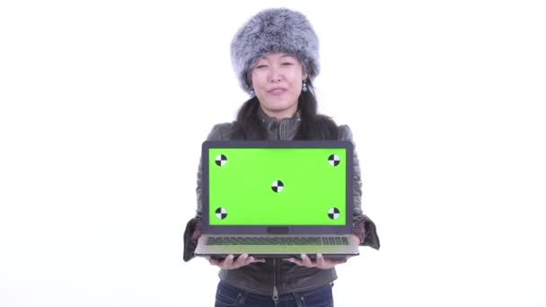 Feliz hermosa mujer asiática hablando mientras muestra el ordenador portátil — Vídeo de stock