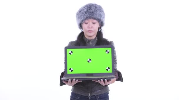 Happy beautiful Asian woman showing laptop and looking surprised — Stock Video