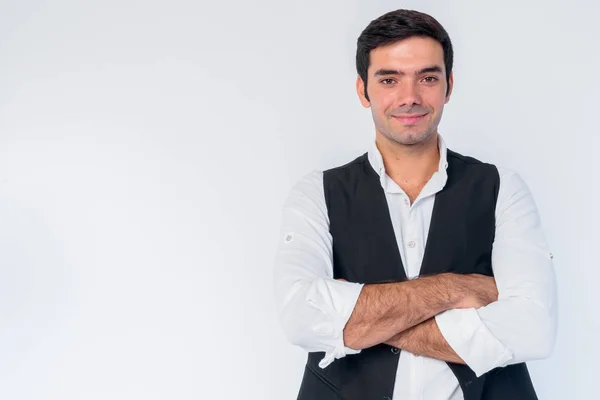 Retrato de feliz joven guapo empresario persa sonriendo con los brazos cruzados —  Fotos de Stock